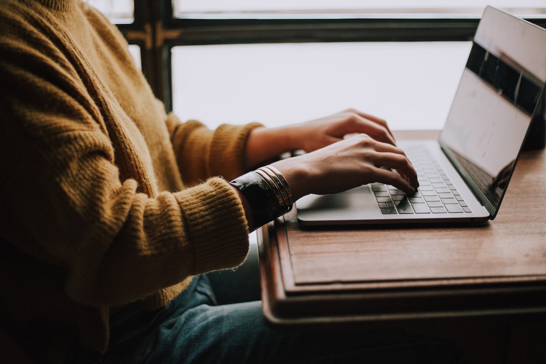 Person typing on a laptop while reviewing finances